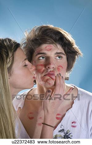 Young man being kissed all over by girl View Large Photo Image Stock Image - Young man being kissed all over by girl. Fotosearch