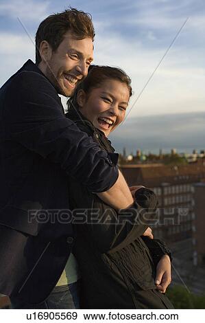 Stock Photo - Young man cuddling on his girlfriend. Fotosearch