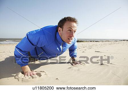 Young man doing push ups on sandy beach View Large Photo Image Stock Image - Young man doing push ups on sandy beach. Fotosearch