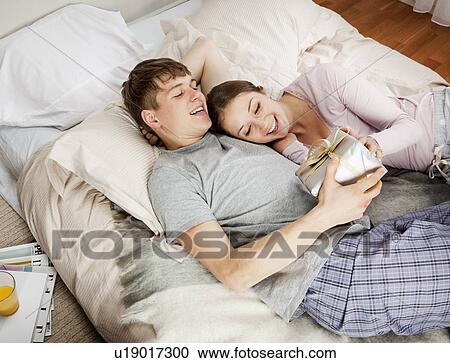 Stock Image - Young man gives present to girlfriend. Fotosearch