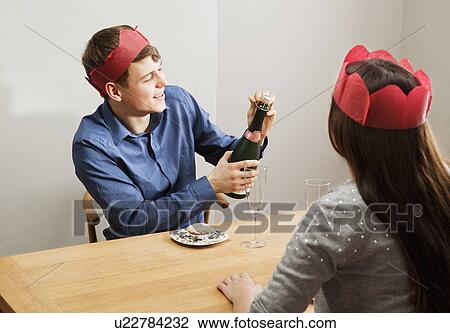 Young man opening champagnebottle View Large Photo Image Stock Image - Young man opening champagnebottle. Fotosearch