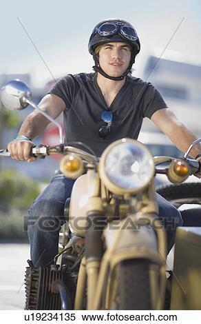 Young man riding a motorbike View Large Photo Image Stock Photography - Young man riding a motorbike. Fotosearch