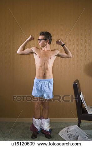 Stock Photo - Young man shows flexes arm muscles.. Fotosearch