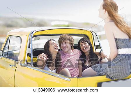 Stock Photograph - Young people sitting on back of pickup. Fotosearch