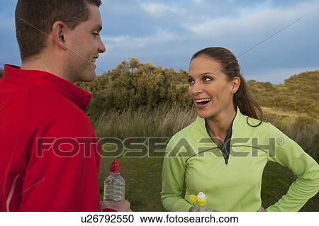 Stock Image - Young smiling couple drinking water. Fotosearch