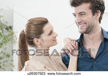Stock Image - Young smiling couple together at home. Fotosearch