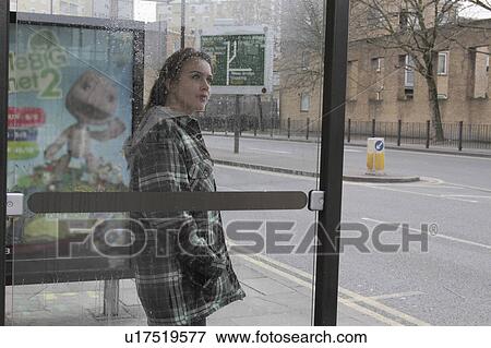 Young woman at bus shelter in rain View Large Photo Image Stock Photo - Young woman at bus shelter in rain. Fotosearch