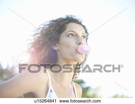 Young woman blowing bubblegum View Large Photo Image Stock Image - Young woman blowing bubblegum. Fotosearch