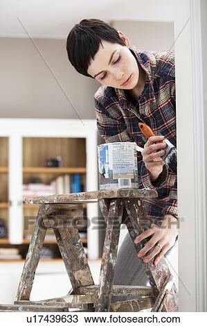 Young woman decorating house View Large Photo Image Stock Image - Young woman decorating house. Fotosearch