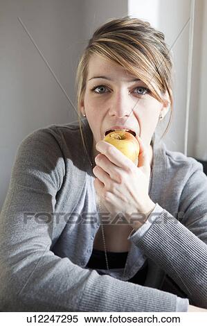 Young woman eating an apple View Large Photo Image Stock Photography - Young woman eating an apple. Fotosearch