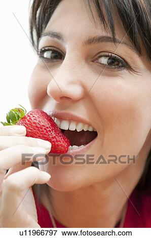 Young woman eating fresh strawberry View Large Photo Image Stock Photo - Young woman eating fresh strawberry. Fotosearch