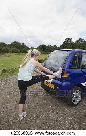 Young woman exercising by electric car View Large Photo Image Stock Image - Young woman exercising by electric car. Fotosearch