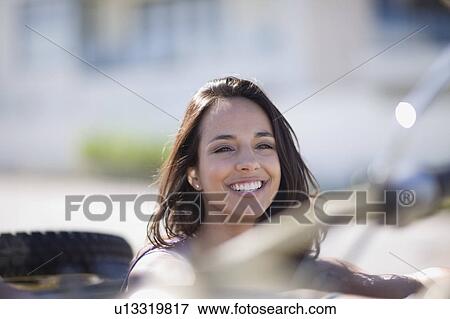 Stock Photo - Young woman in a convertible. Fotosearch