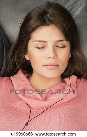 Young woman listening to music, headshot View Large Photo Image Stock Photograph - Young woman listening to music, headshot. Fotosearch