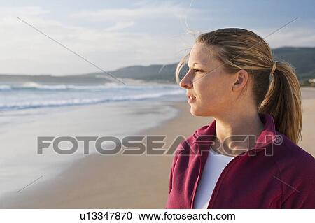 Stock Image - Young woman looking out to the sea. Fotosearch