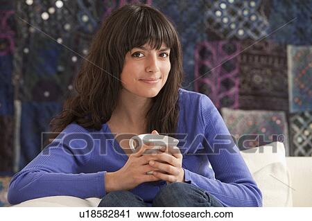 Young woman relaxing with mug View Large Photo Image Stock Image - Young woman relaxing with mug. Fotosearch