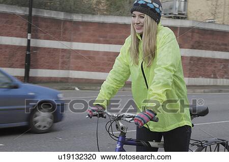 Stock Image - Young woman riding a pushbike. Fotosearch