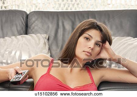 Young woman sitting and watching TV View Large Photo Image Stock Photograph - Young woman sitting and watching TV. Fotosearch