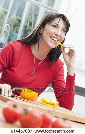Young woman tasting fresh yellow pepper View Large Photo Image Stock Photo - Young woman tasting fresh yellow pepper. Fotosearch