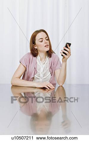 Stock Image - Young woman using new technology. Fotosearch