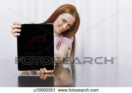 Stock Image - Young woman using new technology. Fotosearch