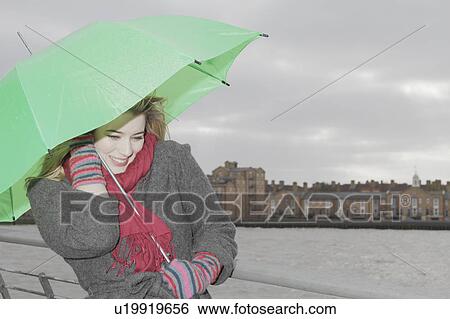 Stock Photograph - Young woman with green umbrella. Fotosearch