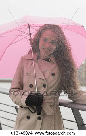 Picture - Young woman with umbrella in rain. Fotosearch