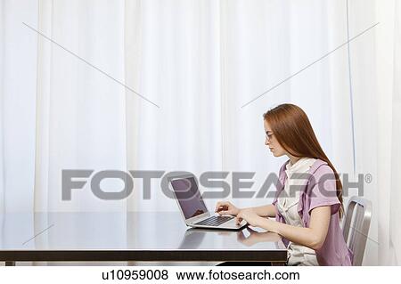 Stock Photo - Young woman working at home. Fotosearch