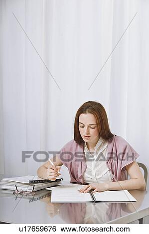 Stock Photograph - Young woman working at home. Fotosearch