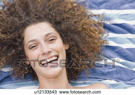 Stock Image - Young women on towel smiling. Fotosearch