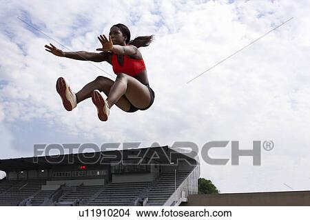 Athlete in midair during long jump View Large Photo Image Picture - Athlete in midair during long jump. Fotosearch