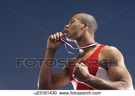 Athlete kissing medal outdoors View Large Photo Image Stock Image - Athlete kissing medal outdoors. Fotosearch