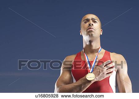 Stock Photo - Athlete wearing medal outdoors. Fotosearch