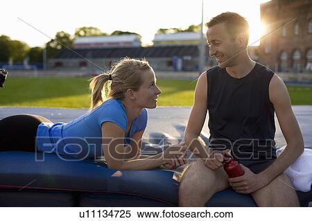 Stock Photography - Athletic couple relaxing in stadium. Fotosearch