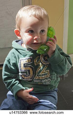 Baby boy playing with toy telephone View Large Photo Image Stock Photograph - Baby boy playing with toy telephone. Fotosearch