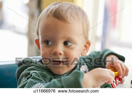 Stock Photograph - Baby boy playing with toy trains. Fotosearch