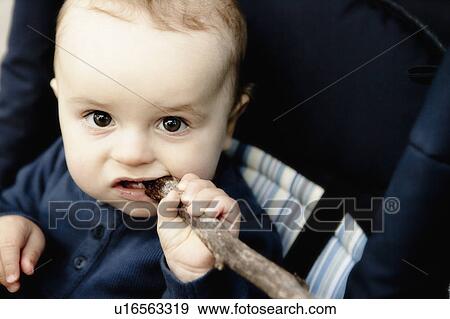 Stock Photo - Baby chewing on wooden stick. Fotosearch