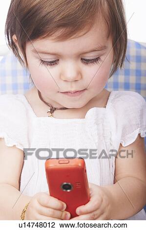 Baby girl playing with cell phone View Large Photo Image Stock Image - Baby girl playing with cell phone. Fotosearch