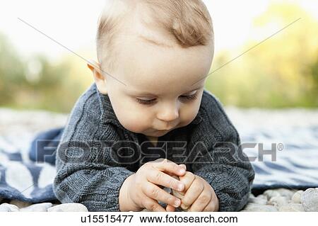 Baby playing with pebbles outdoors View Large Photo Image Stock Photo - Baby playing with pebbles outdoors. Fotosearch