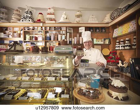 Stock Photo - Baker at register in cake shop. Fotosearch