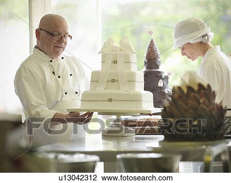 Baker checking decorative wedding cake View Large Photo Image Stock Image - Baker checking decorative wedding cake. Fotosearch