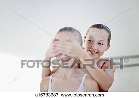 Ballet dancer covering friends eyes View Large Photo Image Stock Photo - Ballet dancer covering friends eyes. Fotosearch