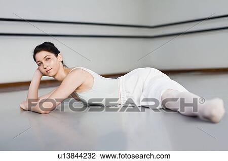 Stock Image - Ballet dancer doing splits in studio. Fotosearch