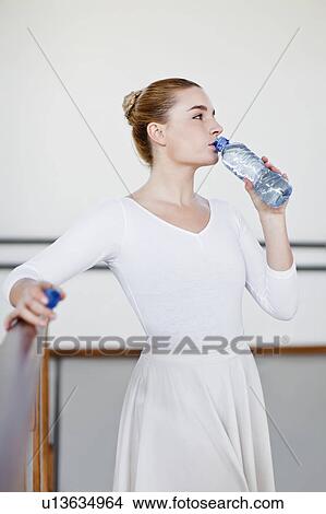 Picture - Ballet dancer drinking water in studio. Fotosearch