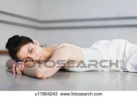 Stock Image - Ballet dancer on floor in studio. Fotosearch