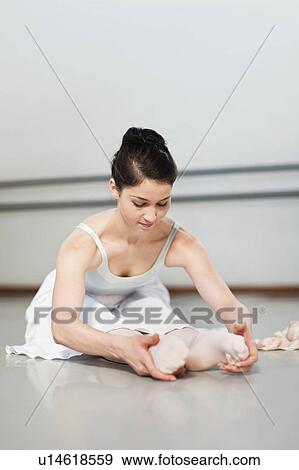 Stock Photo - Ballet dancer stretching in studio. Fotosearch
