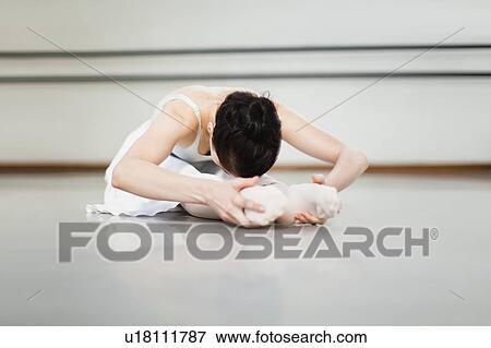 Stock Photo - Ballet dancer stretching in studio. Fotosearch