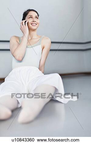 Stock Image - Ballet dancer talking on cell phone. Fotosearch