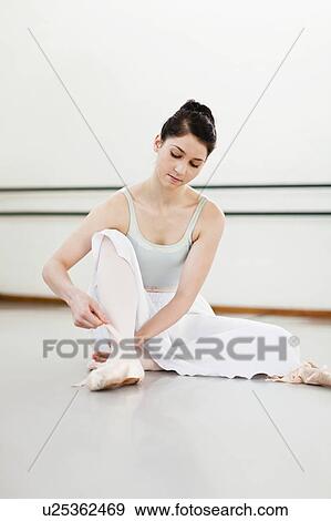 Ballet dancer tying her shoe in studio View Large Photo Image Stock Photo - Ballet dancer tying her shoe in studio. Fotosearch