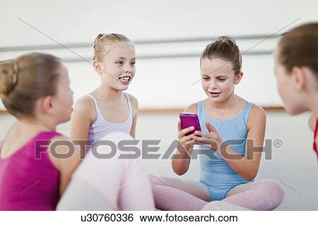Ballet dancer using cell phone in studio View Large Photo Image Stock Photograph - Ballet dancer using cell phone in studio. Fotosearch